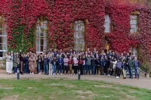 Image of Arqit staff in front of building covered in red ivy